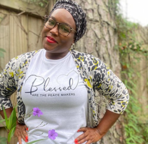 Woman wearing a headscarf and a shirt that says ‘Blessed are the peacemakers.’ Woman wearing a headscarf and a shirt that says 'Blessed are the peacemakers.'